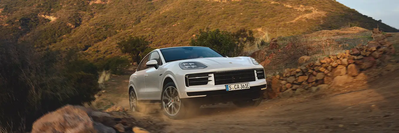 2025 Porsche Cayenne Coupe in white driving on dirt road